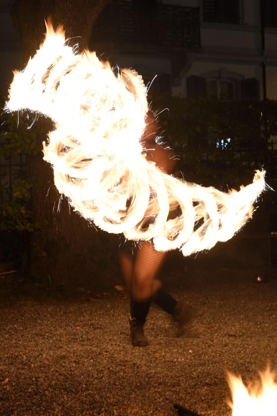 Person jongliert mit Feuer in der Nacht.