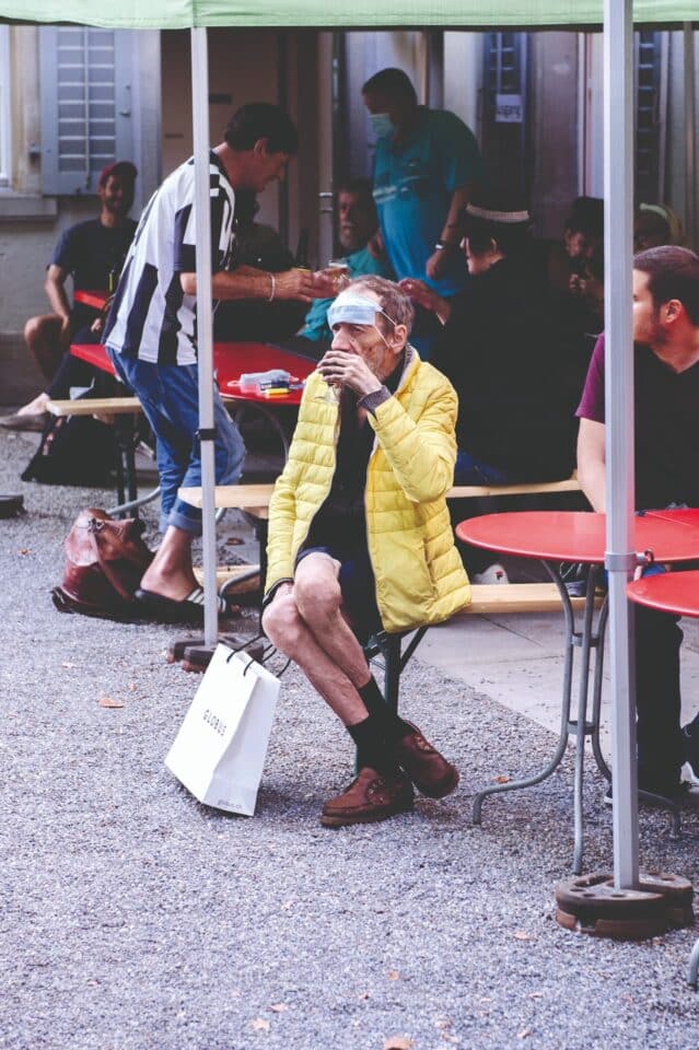 Menschen sitzen an Tischen im Suneboge-Hof