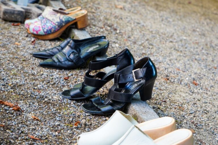 Verschiedene Damenschuhe auf Steinboden aufgereiht