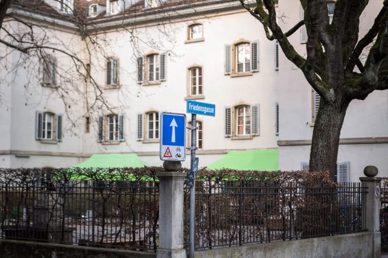 Strassenschild Friedensgasse vor historischem Suneboge-Gebäude