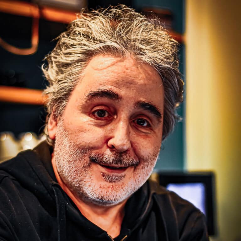 Lächelnder Mann mit grauem Bart und welligem Haar